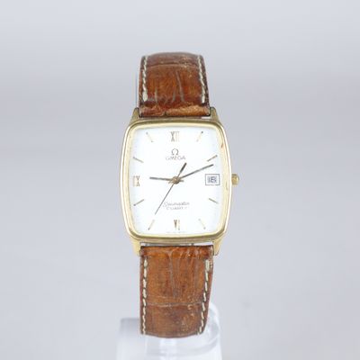 a close up of a watch on a stand on a white surface