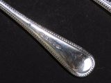 two spoons and a fork on a black surface