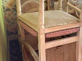 several chairs and a table in a room with a floral wallpapered wall