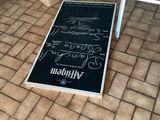 a sign on the floor of a room with a chair next to it