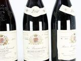 three bottles of wine sitting next to each other on a white surface