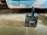 a small machine that is sitting on the ground next to a car