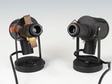 two cameras that are sitting on a stand