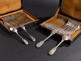 pair of silverware in a leather case on a black surface