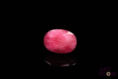 an image of a pink stone on a black surface