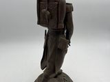figurine of a man with a backpack on his back
