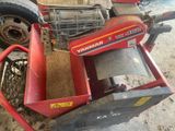 a small red machine that is sitting on the ground