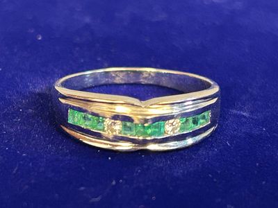 an image of a ring with green stones on it