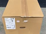 a cardboard box sitting on the ground with a sticker on it