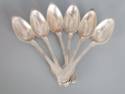 six silver spoons are arranged in a row on a gray surface