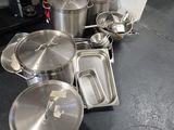 de nombreuses casseroles et poêles posées par terre dans la cuisine
