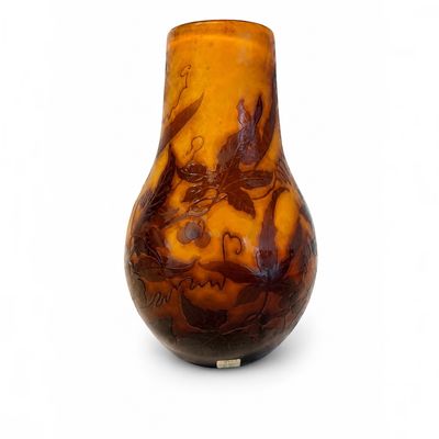 un vase brun orné d'un motif sur une surface blanche