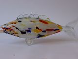 a glass fish that is sitting on a white surface