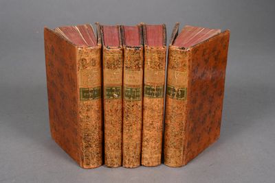 three old books are stacked on top of each other on a table