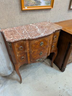 a marble top chest of drawers in a room
