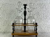 quatre vases en verre posés sur un socle en bois, sur une table