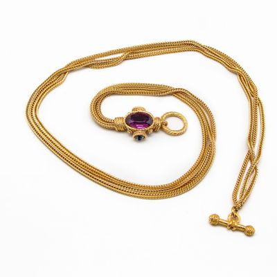 une chaîne en or avec un pendentif orné d'une pierre violette