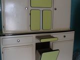 an old fashioned kitchen with a green and yellow cabinet