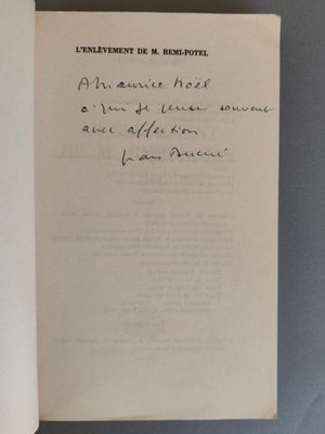 un livre ouvert, sur lequel repose une lettre manuscrite, posé sur une table