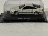 a toy car in a clear case on a white surface