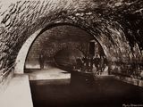 une photo en noir et blanc d'un tunnel dans lequel se trouvent des personnes