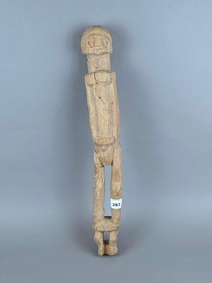 l'image d'une statue en bois représentant un homme avec un chapeau sur la tête