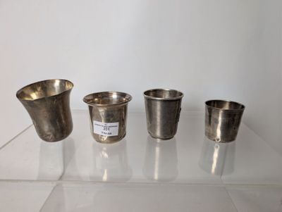 three silver cups sitting on top of a glass table