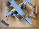 un petit avion en carton posé sur une table, dans une boîte en carton
