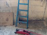 a ladder leaning against a wall next to a blue chair