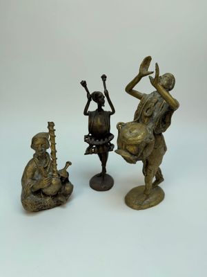 trois figurines en bronze représentant un homme jouant d'un instrument de musique