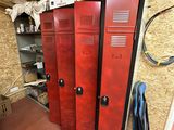 trois casiers rouges dans une pièce où se trouve une chaise dans un coin