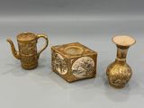 two gold vases and a teapot are sitting on a table