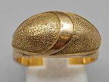 a close up of a gold ring on a white surface