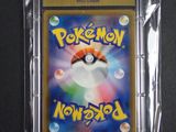 the pokemon card is in a plastic case on a black surface