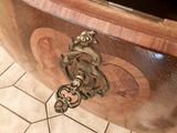 a wooden bowl with a handle on it on a tiled floor