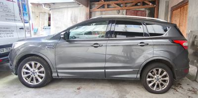 une voiture argentée garée dans un garage à côté d'une camionnette