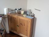 an image of a kitchen with a wooden cabinet and a microwave