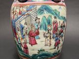 a large vase with a painting on it on a table