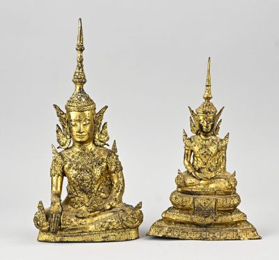 une paire de statues en or représentant des bouddhas assis sur un socle