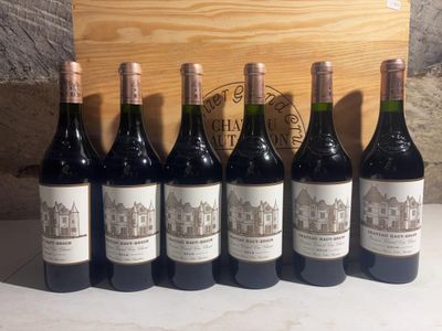 six bottles of wine are lined up in front of a wooden box