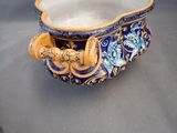 a blue and gold bowl with a handle on a table