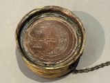 a gold coin sitting on a chain on a table