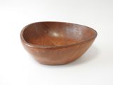 un bol en bois posé sur une surface blanche