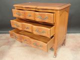 a wooden dresser with four drawers on it