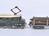 deux petits trains jouets transportant des bûches, posés sur une surface blanche