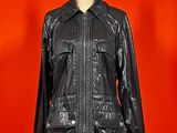 black leather jacket on mannequin stand against red background