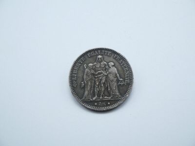 une pièce d'argent sur laquelle figure l'image d'un groupe de personnes