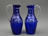 une paire de vases en verre bleu ornés de fleurs sur fond gris