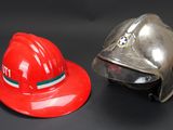 two firemen hats sitting next to each other on a table