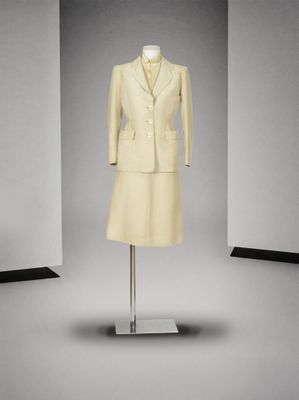 une robe et une veste posées sur un mannequin dans une pièce